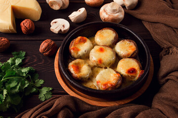 Traditional Georgian dish, appetizer, stuffed mushrooms, Sulguni cheese, baked in a Ketzi clay pan, on a wooden table, close-up, no people,