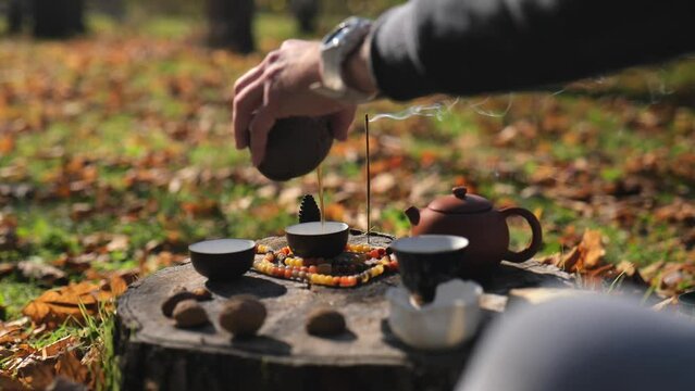 a man pours pu-erh from pottery into bowls waiting for tea. chinese tea ceremony concept