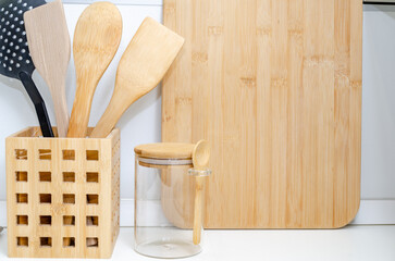 Eco friendly Bamboo kitchen utensils on kitchen table. wooden and plastic spatulas for cooking