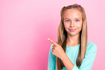 Portrait of sweet nice girl indicate finger empty space offer proposition isolated on pink color background