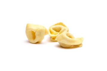 Tortellini stuffed pasta isolated on white background, closeup. Tortellini with raw prosciutto. Italian food