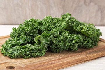 Fresh Curly Kale leaves on a wooden cutting board. Healthy eating concept. Superfoods. Organic food.