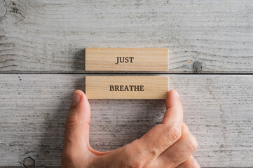 Two wooden blocks with a Just breathe sign on them