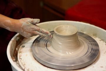 Closrup photohgraphy of child hands,making vase on pottery wheel.