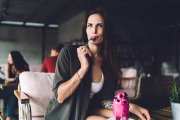 Woman tasting fresh beverage in restaurant