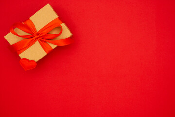 Gift box against red background. Holiday greeting card. Copy space. The concept of holidays and love