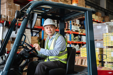 Fototapeta premium A warehouse worker forklift operator moves packages around with a manufacturing facility.