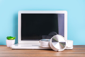 Notebook computer laptop, with headphones for  music, woman hands in picture. Distant learning,...