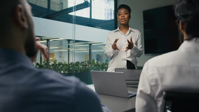 African American businesswoman mentor business coach company CEO female leader teaching business team multiracial diverse coworkers present startup project corporate training studying in office study