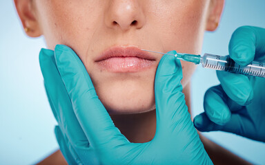 Botox, hands and mouth surgery with a woman and doctor in studio on a blue background for face change. Beauty, skin and injection with a surgeon holding a syringe for female client facial filler