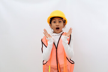 Shocked Asian little girl in the construction helmet as an engineer standing while looking at the camera. Isolated on white with copyspace