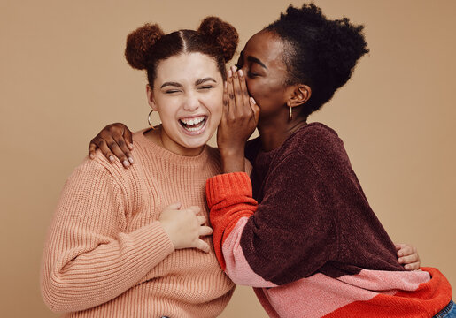 Friends, gossip and women laughing at secret joke on studio background with smile on face. Secrets, rumor and whisper in ear, black woman with happy woman discuss funny announcement for advertisement