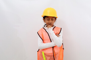 Thoughtful Asian little girl in the construction helmet as an engineer thinking something while...
