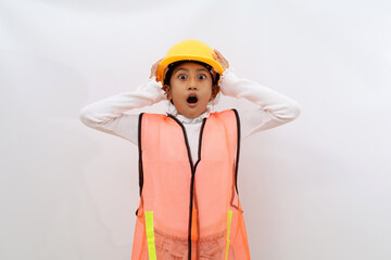 Shocked Asian little girl in the construction helmet as an engineer standing while holding her head. Isolated on white