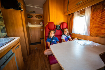 Children seated in back seats in motorhome.