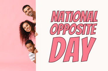 Happy interracial family and big poster with text NATIONAL OPPOSITE DAY on pink background