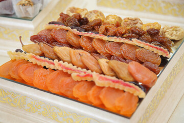 bowl with different tasty dried fruits on wooden table