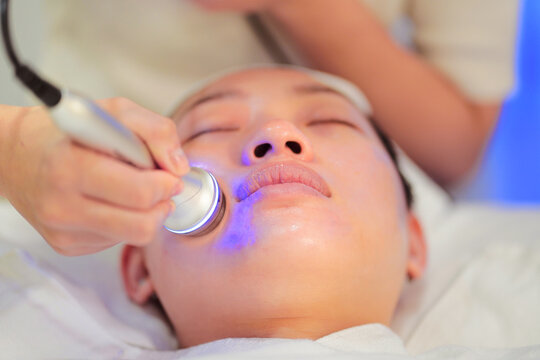 Female beautician doing RF skin treatment