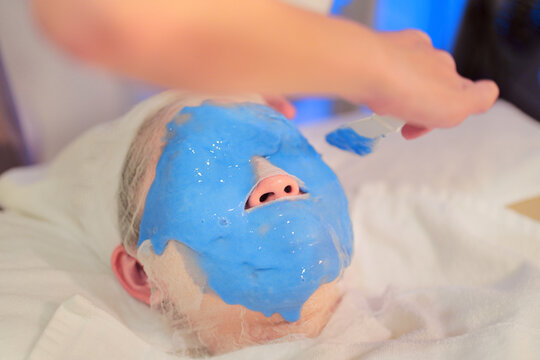 Crop beautician applying alginate mask