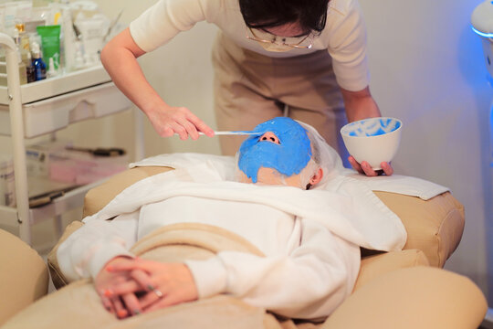 Crop beautician applying alginate mask