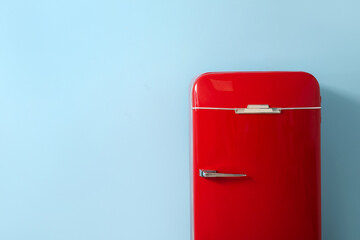 Stylish retro fridge near blue wall