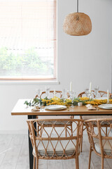 Beautiful table setting with mimosa flowers and candles in room