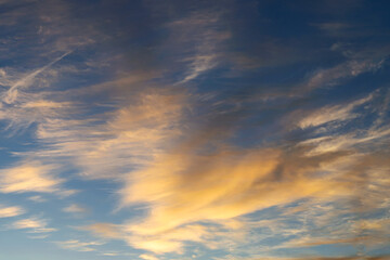blue sky with golden clouds beautifully illuminated by the sun as a natural background