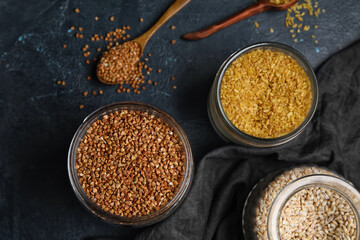 Jars with cereals on dark background, closeup