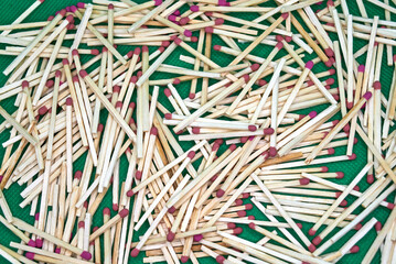 Red head matches scattered on green background.