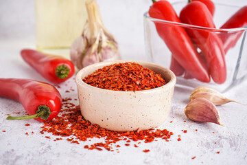 Bowl of chipotle chili flakes on light background
