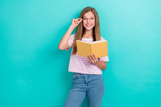 Portrait of cheerful smart person hand touch eyewear hold opened book isolated on cyan color background
