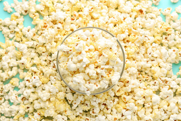 Bowl full of tasty popcorn on color background
