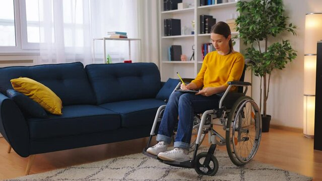 Young woman wheelchair user drawing sketches, artist, creative hobby, lifestyle