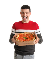 Happy young man with box of tasty pizza on white background