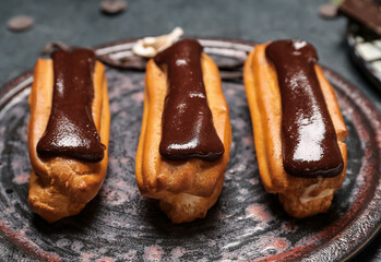 Plate with chocolate eclairs, closeup