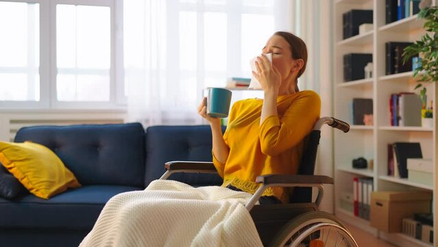 Young woman wheelchair user having influenza symptoms, running a fever