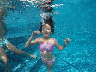 criança feliz em mergulho em piscina 