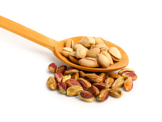 Spoon with tasty pistachio nuts and kernels isolated on white background