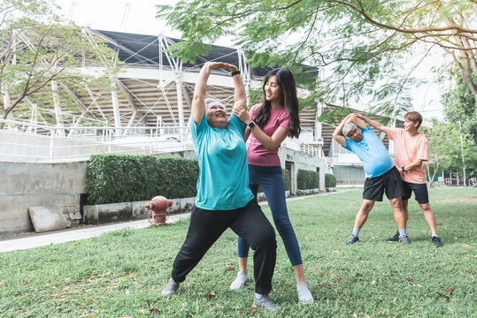 Asian family, Son and daughter helping elderly father and mother which is obese in the belly to exercise starting from stretching the arm muscles. to elderly health care and exercise concept. - Powered by Adobe