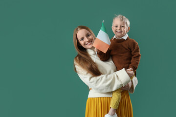 Beautiful woman with her little son and flag of Ireland on green background