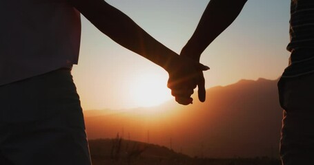 Silhouette of couple holding hands at sunset. Romantic couple in love, support each other concept. Closeup slowmotion - Powered by Adobe