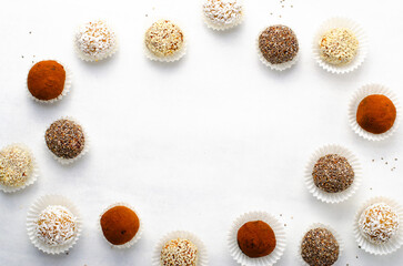 Fototapeta na wymiar Assorted Vegan Sweets, Delicious Candy Balls with seeds, nuts and cocoa powder, Healthy Candies on Bright Background