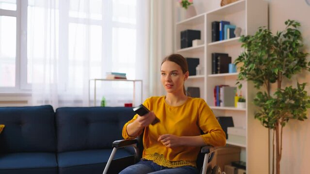 Young woman living with disability watching TV in room alone, relaxation at home
