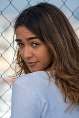 Obraz premium Attractive young woman near a wire fence