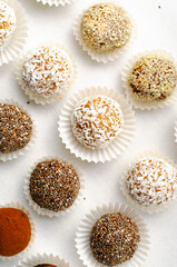 Assorted Vegan Sweets, Delicious Candy Balls with seeds, nuts and cocoa powder, Healthy Candies on Bright Background