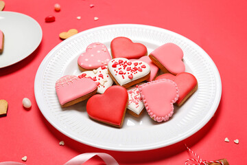 Plate of tasty heart shaped cookies on red background, closeup. Valentine's Day celebration