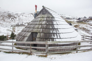 Velika planina mountain 1666 m in Kamnik Savinja Alps in Slovenia, winter hiking in herdsmen’s huts village covered with snow