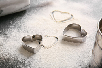 Sprinkled flour and heart shaped cookie cutters on table. Valentines Day celebration