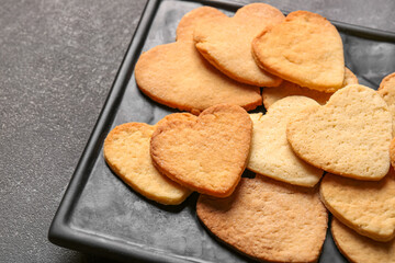 Plate with sweet heart shaped cookies on dark background, closeup. Valentines Day celebration