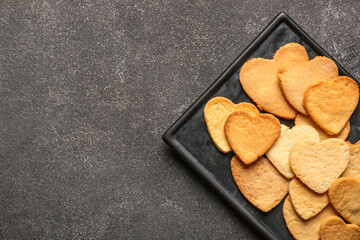 Plate with sweet heart shaped cookies on dark background. Valentines Day celebration